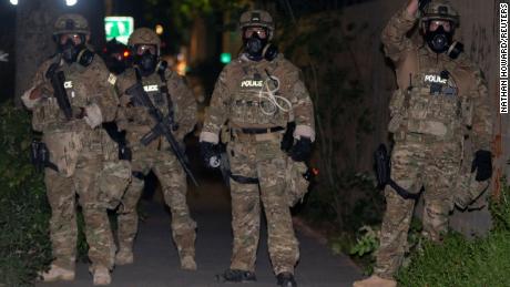 Agentes de la ley federales desplegados para proteger monumentos y edificios federales se enfrentan a los manifestantes contra la desigualdad racial el viernes en Portland, Oregon. 